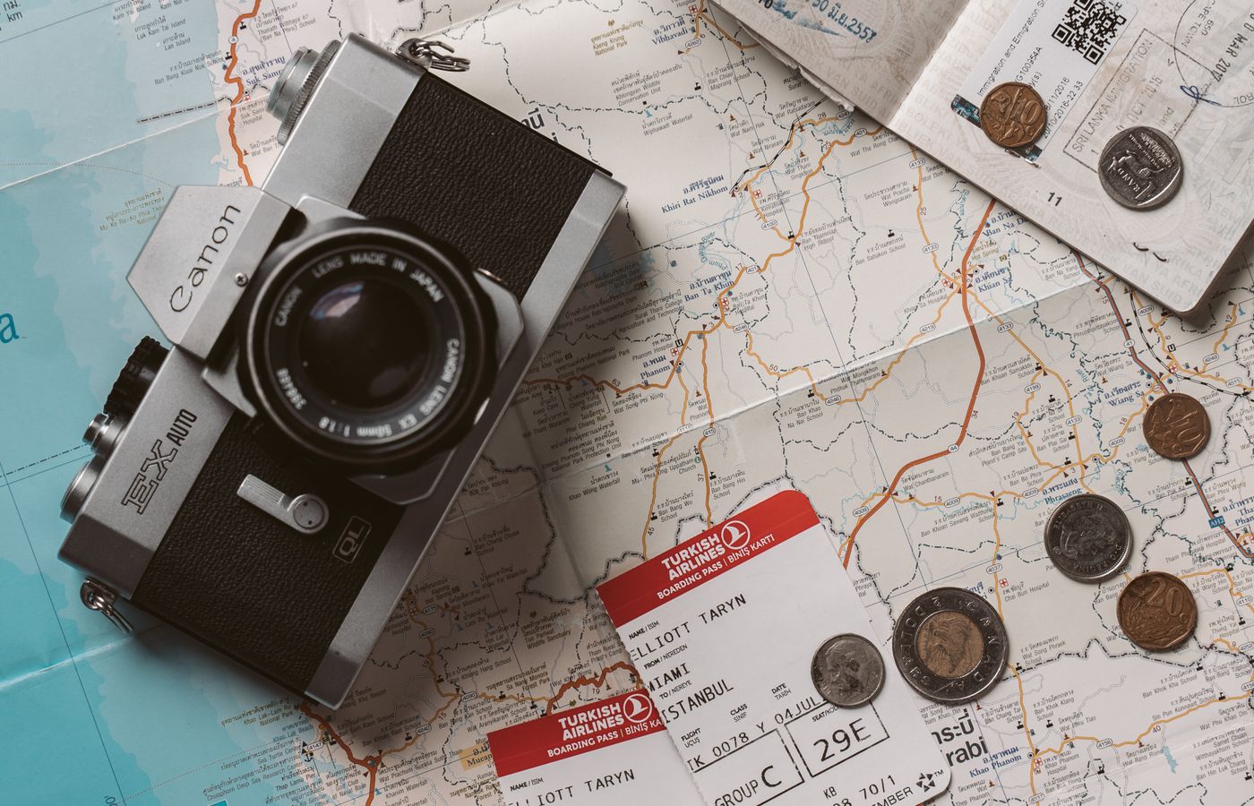 Travel documents, tickets and camera arranged on a world map